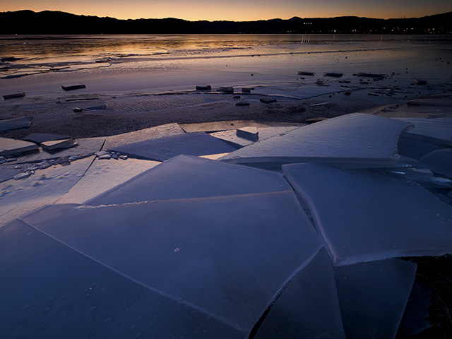 写真家喜多規子がM.ZUIKO DIGITAL ED 8-25mm F4.0 PROで撮影した夕焼けを写す氷と湖面の写真
